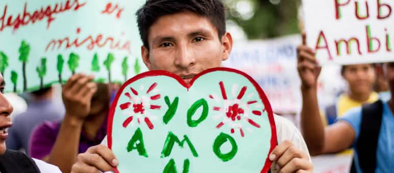 Der Wald liegt ihnen am Herzen - deshalb gehen die Menschen auf die Straße Ein Demonstrant in Iquitos, Peru, zeigt ein Herzplakat "Ich liebe den Wald" auf Demo gegen Abholzung für Kakaoplantagen