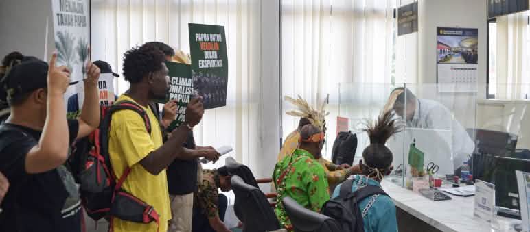 rechts indigene Papua vor einer Glasscheibe, links "Papua braucht Gerechtigkeit, keine Ausbeutung"