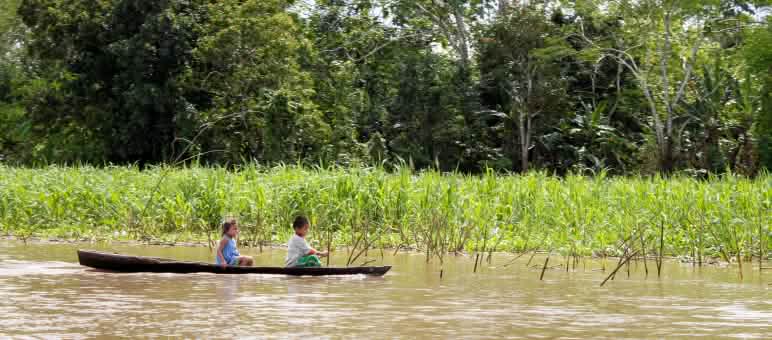 Der Amazonas ist die Lebensader der Bewohner von Tamshiyacu – und ihre einzige Verbindung zur Außenwelt Zwei Kinder fahren auf dem Amazonas-Fluss Boot