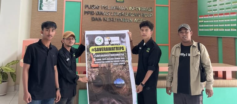 vier Leute mit großem Plakat #SaveRawaTripa in Behörde