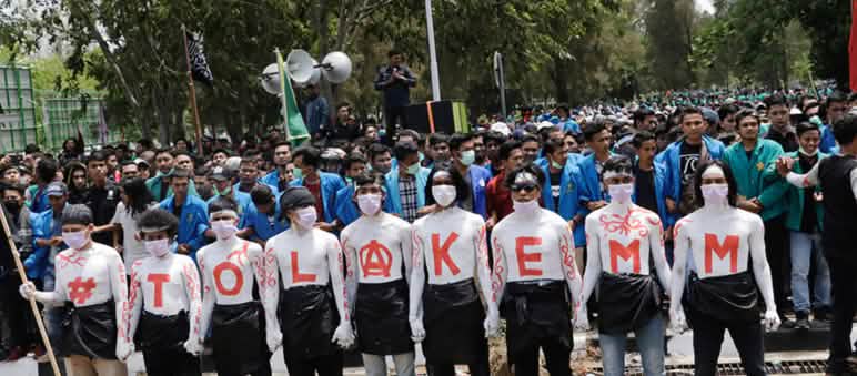 NEIN zu EMM in Großbuchstaben auf den Hemden von neun Demonstranten