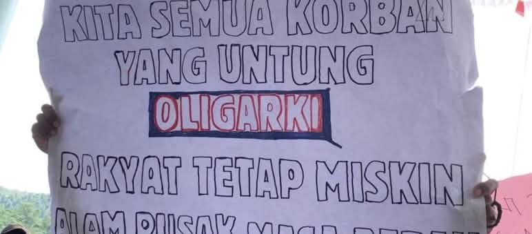 Banner mit "Wir alle sind Opfer. Gewinnerin ist die Oligarchie. Das Volk bleibt arm. Die Natur ist kaputt. Die Zukunft für Tourismus ist düster."