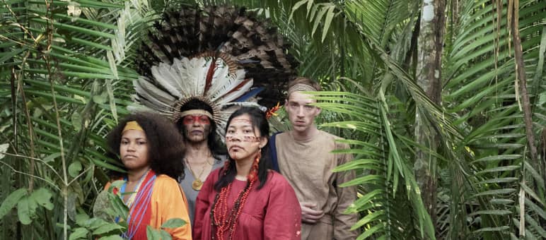 Schauspieler aus dem Theaterstück Antigone im Amazonas stehen im Regenwald