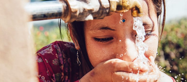 Sauberes Trinkwasser ist ein Menschenrecht. Frisches Wasser muss allen zur Verfügung stehen – niemand soll es in Plastikflaschen teuer kaufen müssen Mädchen trinkt aus Wasserhahn