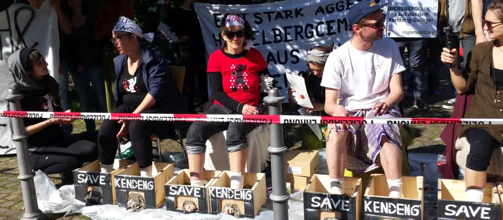 Protest vor der Stadthalle Heidelberg: Aktivisten mit einbetonierten Füßen Protest gegen HeidelbergCement: Aktivisten betonieren ihre Füße ein