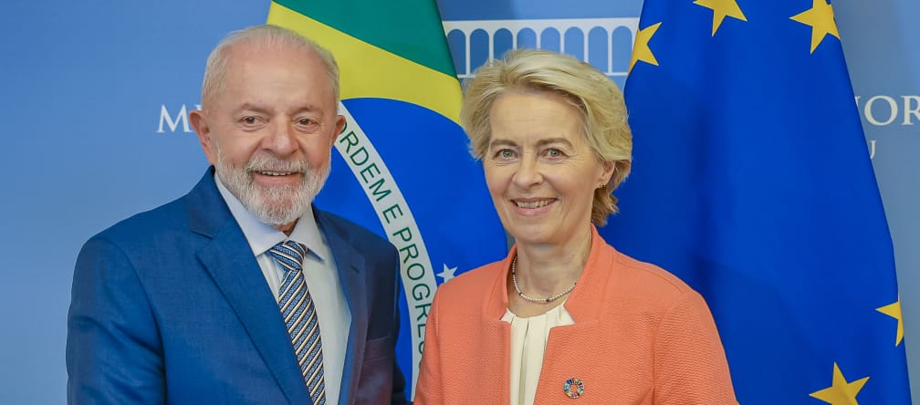 Die Präsidentin der Europäischen Kommission, Ursula von der Leyen und Brasiliens Präsident Lula da Silva schütteln sich vor den Landesfahnen die Hände