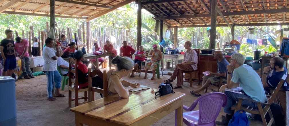 Eine Gruppe von Personen bei einem Treffen in einer offenen Hütte