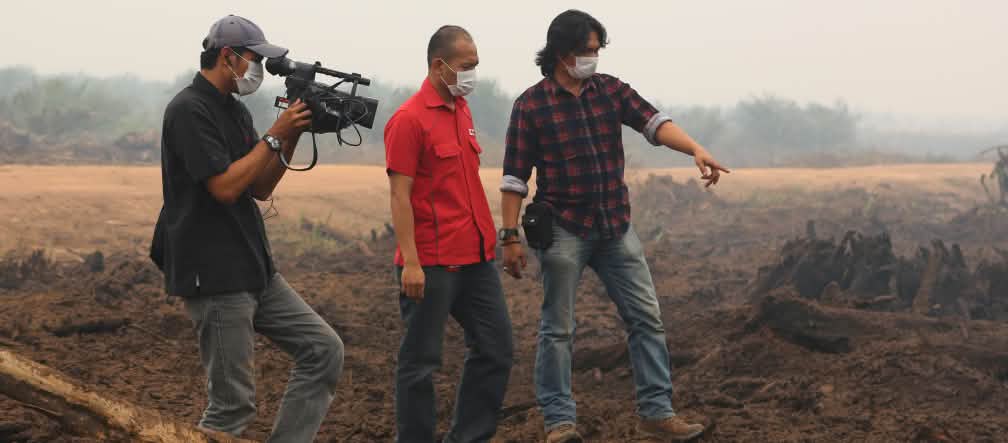 „1.000 Hektar Torfregenwald wurden hier verbrannt“, so Umwelt-Aktivist Feri Irawan im TV-Interview. „Doch noch können wir den größten Teil des Waldes retten.“ Feri Irawan mit Filmteam auf abgebrannter Fläche