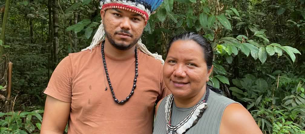 Porträt einer indigenen Frau mit Federhalskette rechts und eines jungen indigenen Mannes mit Federkrone rechts
