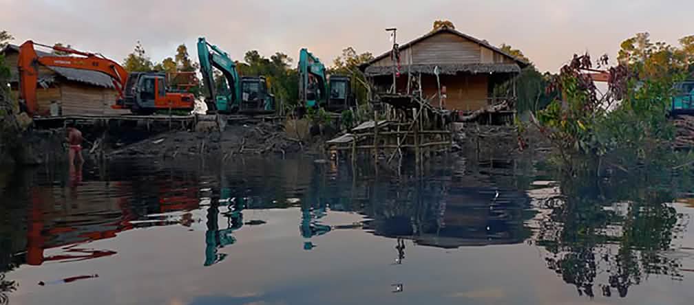 Bagger zerstören Häuser an einem Fluss in Indonesien