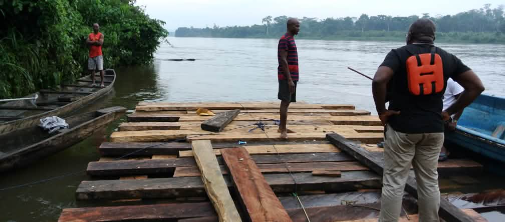 Odey Oyama (mit Schwimmweste) auf einem Floß von Holzfällern
