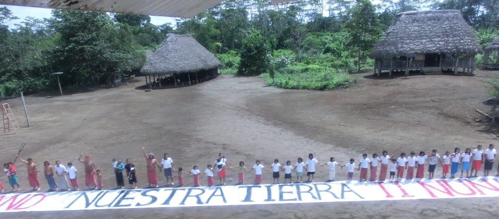 Die Indianer in Ecuador stellen sich der Ölindustrie in den Weg Unser Land - nuestra tierra! Menschenkette mit Banner gegen Landraub in Ecuador