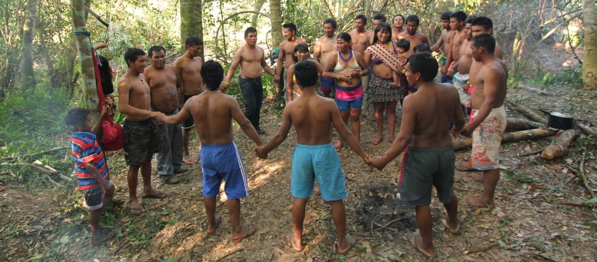 Indigene Ka'apor  - Kinder, Frauen und Männer - fassen sich an den Händen und bilden einen Kreis im Regenwald