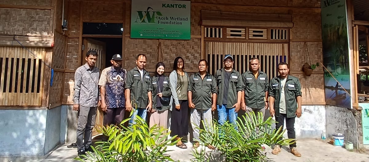 Gruppenfoto des AWF Team vor dem Bürogebäude aus Rattan und Bambus