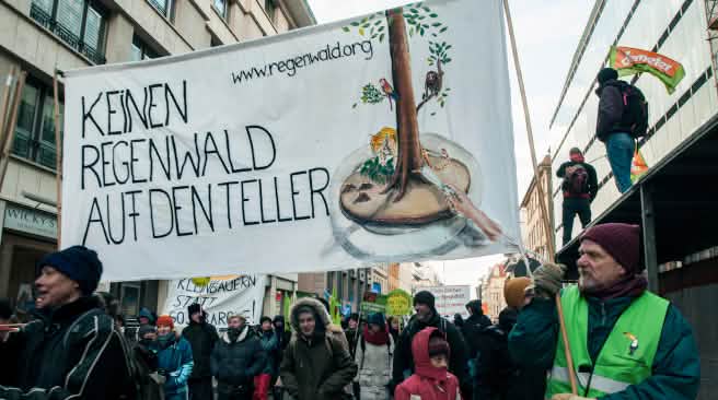 Demonstranten vor dem Berliner Hauptbahnhof halten ein Banner hoch, auf dem "Keinen Regenwald auf den Teller" steht