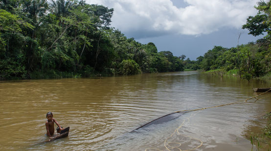 Ein Kind badet in einem Fluss im tropischen Regenwald