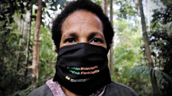 Papua-Frau mit Mundschutz "Schütz den Wald - der Wald schützt uns"