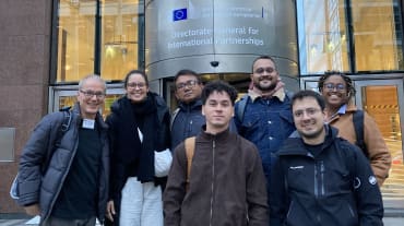 Gruppenfoto von 7 Personen vor dem Eingang eines Gebäudes der EU-Kommission in Brüssel