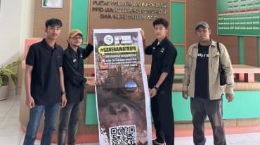 vier Leute mit großem Plakat #SaveRawaTripa in Behörde