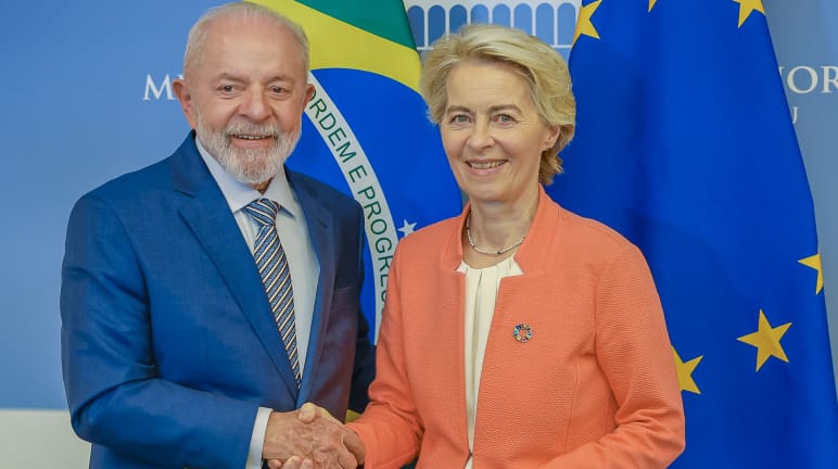Die Präsidentin der Europäischen Kommission, Ursula von der Leyen und Brasiliens Präsident Lula da Silva schütteln sich vor den Landesfahnen die Hände