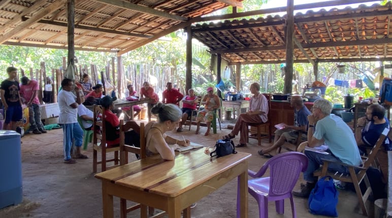 Eine Gruppe von Personen bei einem Treffen in einer offenen Hütte