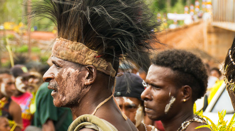 Die Mahuze wehren sich gegen Plantagen Männer mit Kopfschmuck bei einem Fest in Papua
