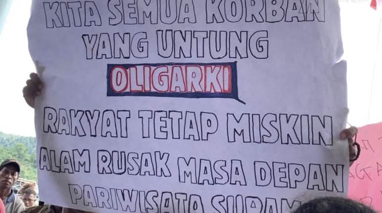 Banner mit "Wir alle sind Opfer. Gewinnerin ist die Oligarchie. Das Volk bleibt arm. Die Natur ist kaputt. Die Zukunft für Tourismus ist düster."