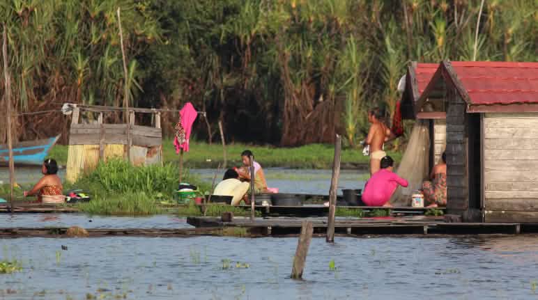 Fischfang ist unmöglich, denn Sinar Mas hat den Sembuluh-See auf Borneo verschmutzt Leben am Sembuluh-See, Frauen hocken auf Stegen und waschen Wäsche