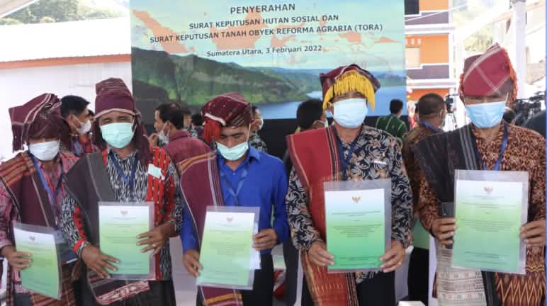 Präsident Joko Widodo persönlich hat die Urkunden der Anerkennung des Indigenen-Waldes überreicht 5 Männer mit Batak-Kleidung zeigen Urkunden