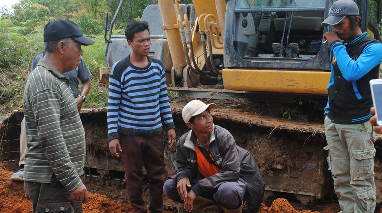 „Was macht ihr hier?“, fragt Wardian (links) die Arbeiter. „Ihr könnt doch nicht einfach die Bäume ausreißen. Das ist mein Land!“ Wardian steht vor einem Bulldozer und diskutiert mit den Arbeitern