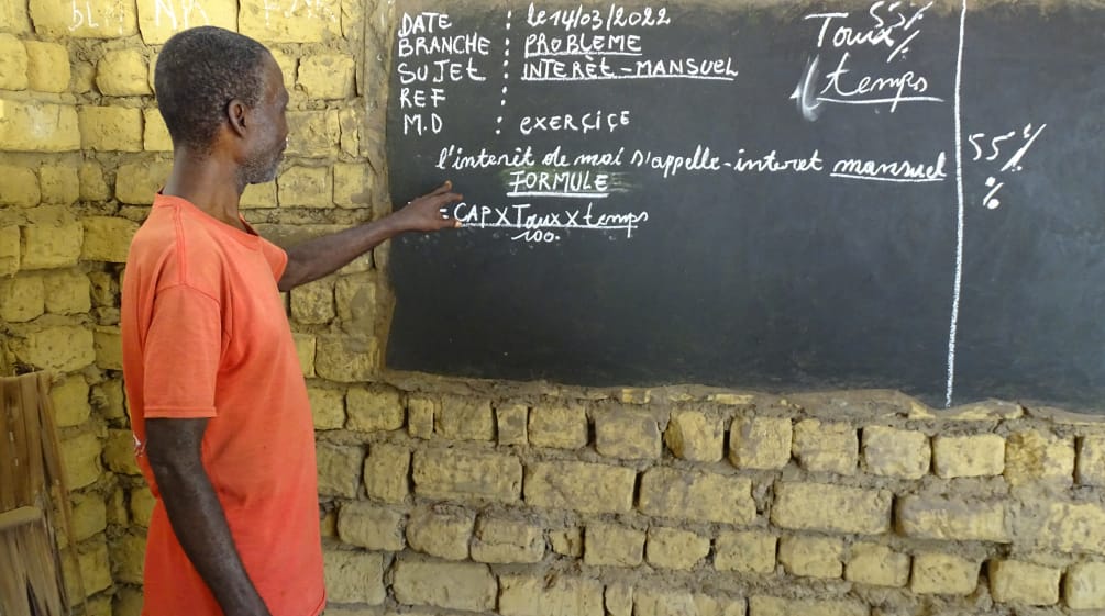 Unterricht im Dorf Bekombo - der Lehrer erklärt monatliche Zinsen Lehrer in einer Dorfschule in der Demokratischen Republik Kongo