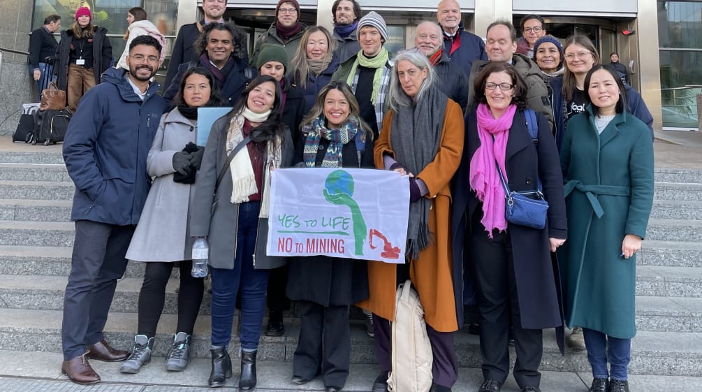 Die Gruppe der Umweltschützer:innen mit Banner auf der Treppe vor dem Europaparlament