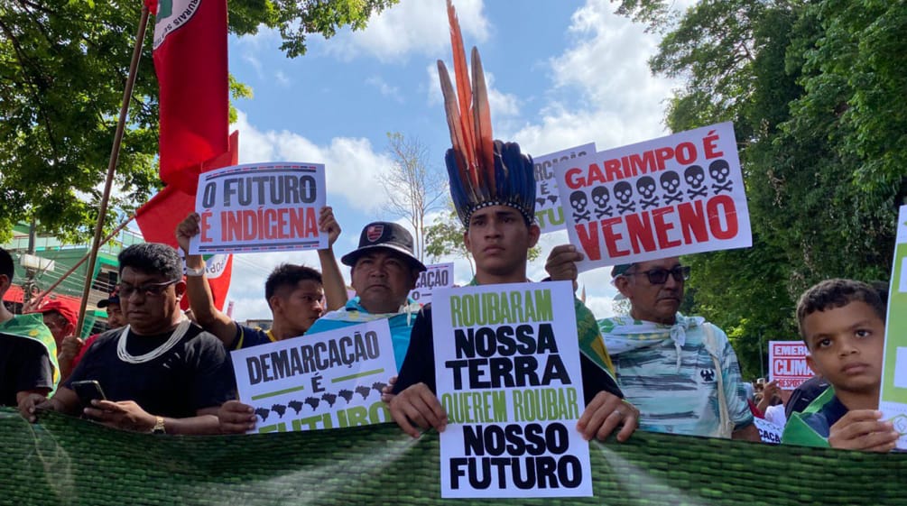 „Marsch der indigenen Völker“ für den Regenwald während des Amazonas-Gipfels in Belém Indigene marschieren in einer Reihe und halten Plakate hoch mit Texten wie: Unser Land ist unsere Zukunft