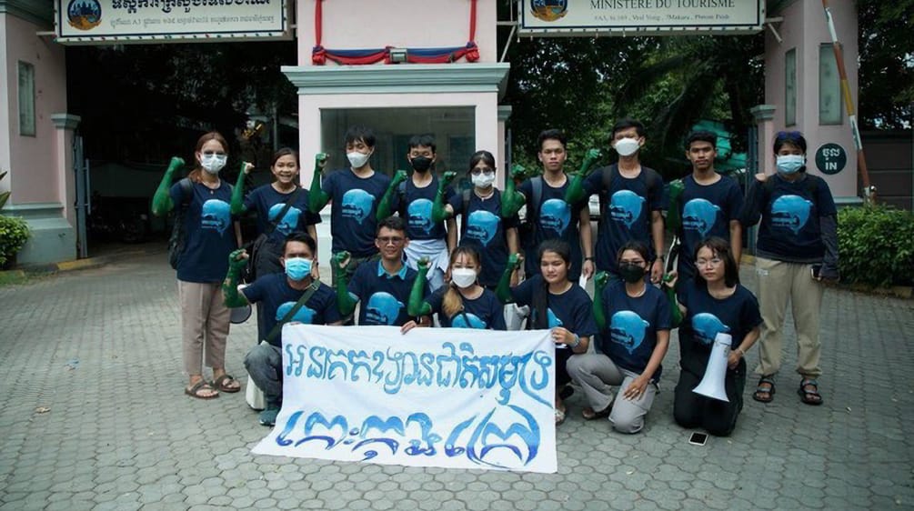 15 Jugendliche stehen und knien vor dem Gebäude des Tourismusministeriums und halten einen Banner in die Kamera. Dort steht: „Koh Kong Island soll ein Meeresnationalpark werden“