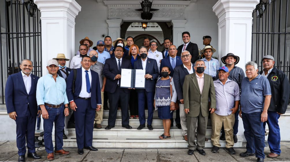 Eine Gruppe von ca. 20 Personen mit dem Präsidenten Panamas in der Bildmitte präsentiert das unterzeichnete Gesetz am Eingang des Regierungspalastes