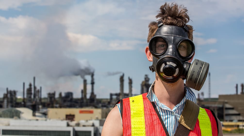 Ein junger Mann demonstriert mit Gasmaske gegen Teersand-Abbau in Kanada