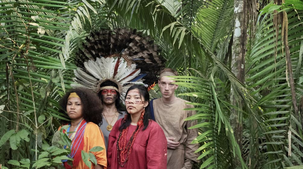 Schauspieler aus dem Theaterstück Antigone im Amazonas stehen im Regenwald