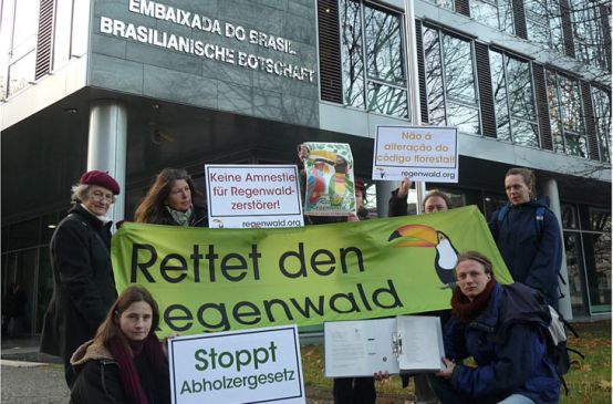 Demonstranten halten Transparente gegen Waldgesetz vor brasilianischer Botschaft