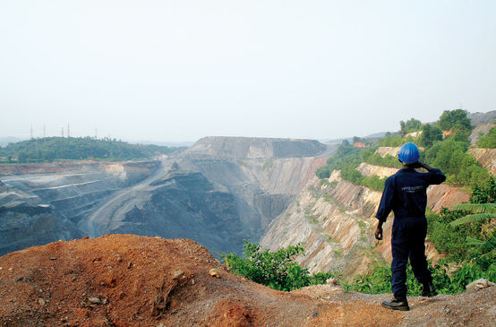Ein Arbeiter sieht in eine große Tagebau-Mine