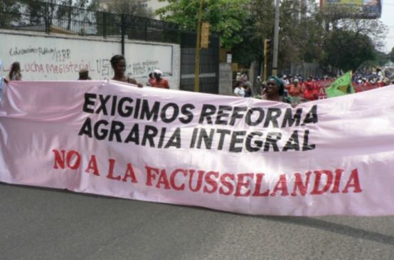 Bauern kämpfen mit einem großen Banner für Umverteilung des Landes