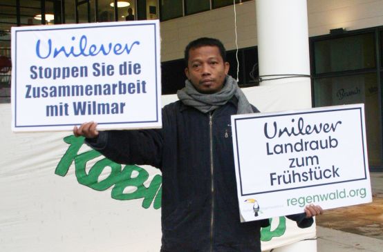 Nordin hält Demo Plakate gegen Unilver hoch