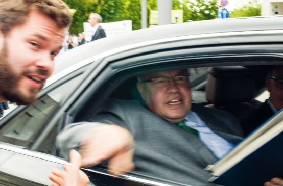 David Vollrath von Rettet den Regenwald reicht Umweltminister Peter Altmeier die Unterschriften durchs Autofenster