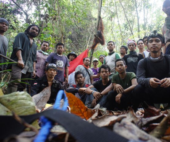 Die Gruppe der Baumpflanzer. Im Hintergrund ein Orang-Utan