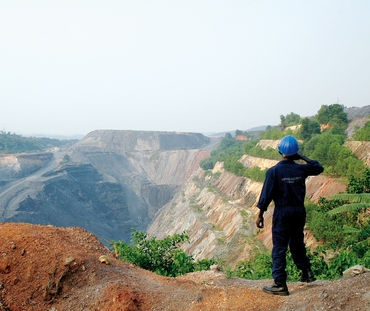 Ein Arbeiter sieht in eine große Tagebau-Mine