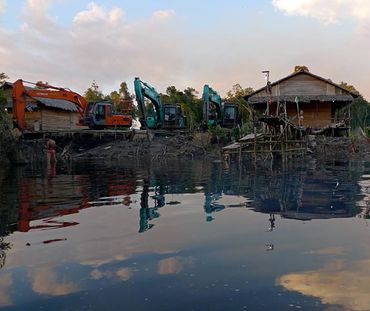 Bagger zerstören Häuser an einem Fluss in Indonesien