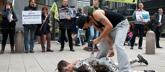Gestellte "Schlangen"-Häutung vor Hamburgs Luxusläden Ein Mensch verkleidet sich als Schlange und wird von einem anderen "gehäutet"