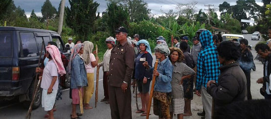 Bauernfamilien protestieren auf einer Landstraße auf Sumatra gegen die Abholzungen und Verhaftungen