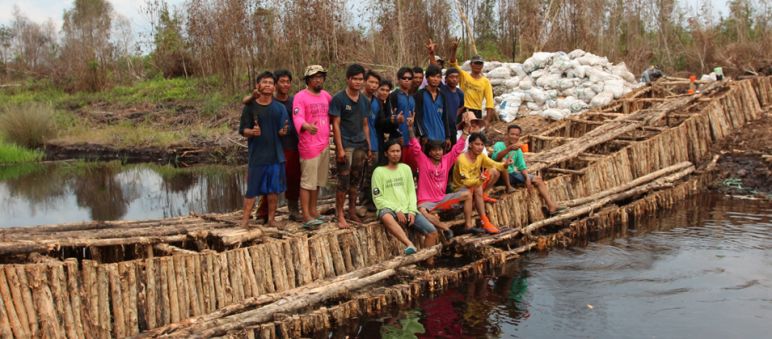 Umweltschützer bauen Holzblockaden, um das Abfließen des Wassers aus den Kanälen zu verhindern Umweltschützer stehen auf einem Damm, den sie aus Holz gebaut haben, um einen Kanal zu blockieren