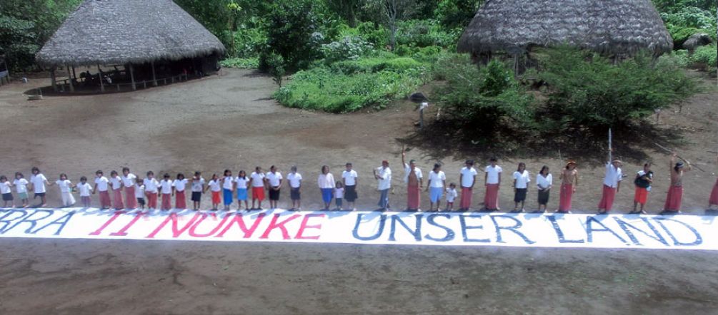 Die Indianer in einem Dorf im Amazonasregenwald richten sich mit einem Banner an die Öffentlichkeit: Dies ist unser Land.
