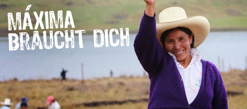 Máxima Acuña lässt sich nicht von den Bedrohungen einschüchtern und kämpft mutig um ihr Land Máxima Acuña erhebt lächelnd ihre rechte Hand. Im Hintergrund sind weitere Bauern und die blaue Lagune zu sehen.